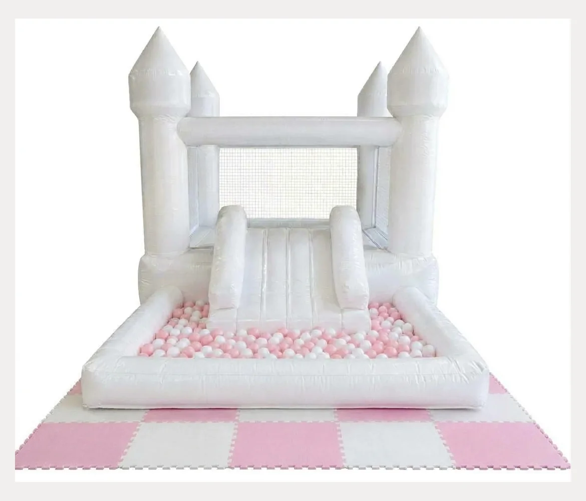 Small white jumping castle with pink and white balls and pink mats